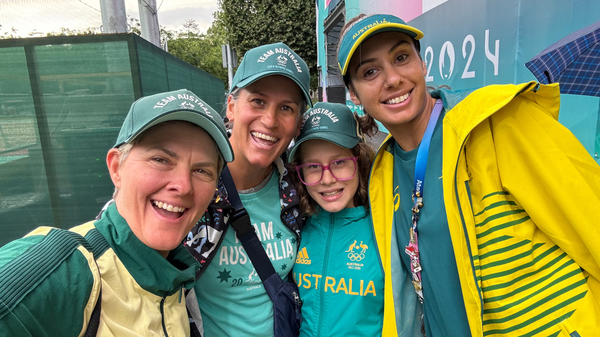 Nat Cook OAM OLY with Taliqua Clancy and Nat's family. Everyone is smiling and wearing green and gold to represent Australia