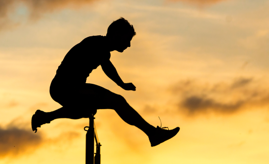 The Price You Pay podcast - silhouette of an athlete jumping over a hurdle with sunset and clouds in the background